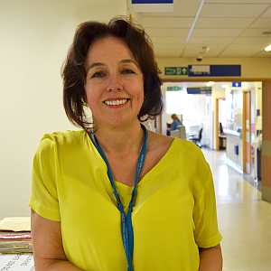 A smiling Marianne wearing a bright yellow top in a hospital background. Dame Marianne Griffiths; the CEO of Brighton and Sussex University Hospitals NHS Trust.