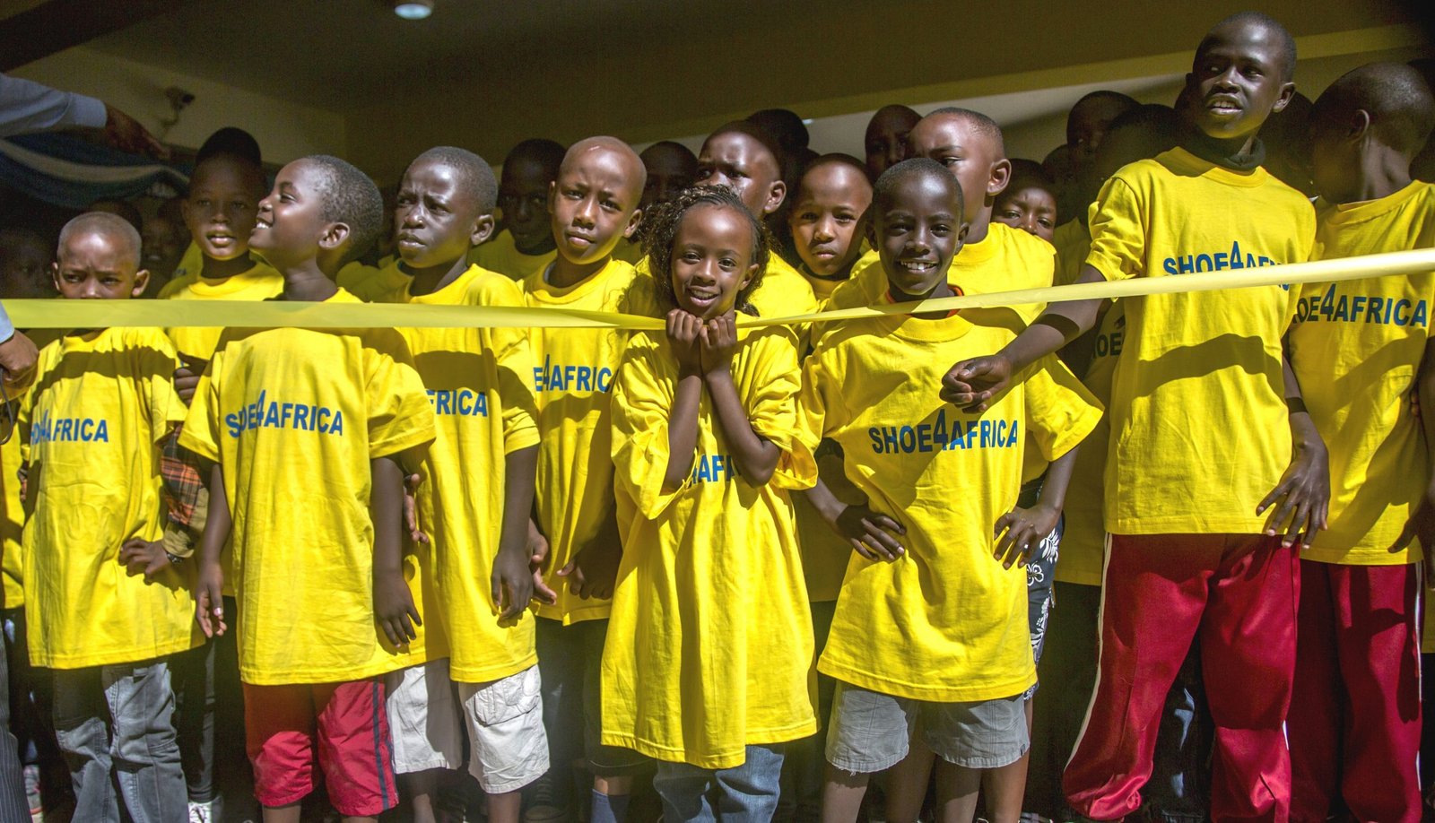 Toby Tanser, CEO/Founder of Shoe4Africa - group of boys wearing yellow t shirts